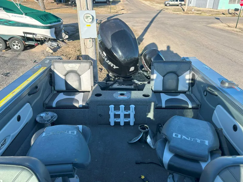 Slide: The Image of 2009 Lund 1950 Tyee Grand Sport boat interior with Mercury engine, seats, and fishing rod holders. - 5