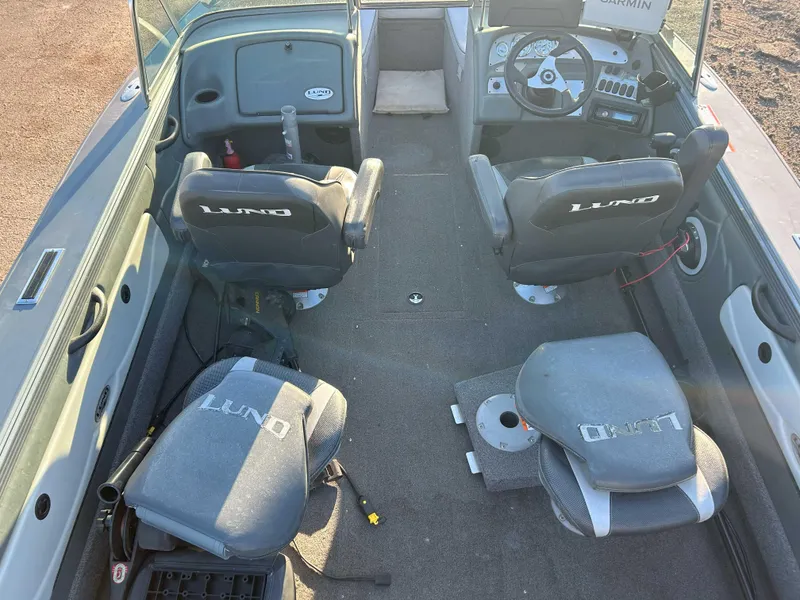 Slide: The Image of Interior of a 2009 Lund 1950 Tyee Grand Sport boat with seating and controls. - 6