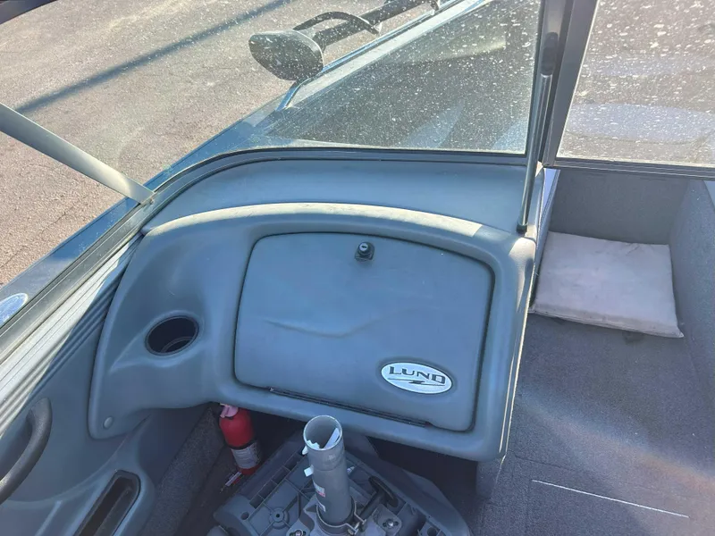 Slide: The Image of Interior of a 2009 Lund 1950 Tyee Grand Sport boat, featuring dashboard and seating area. - 9