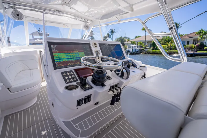 Slide: The Image of 2020 Intrepid 407 Cuddy boat helm with advanced navigation systems and luxurious seating. - 14