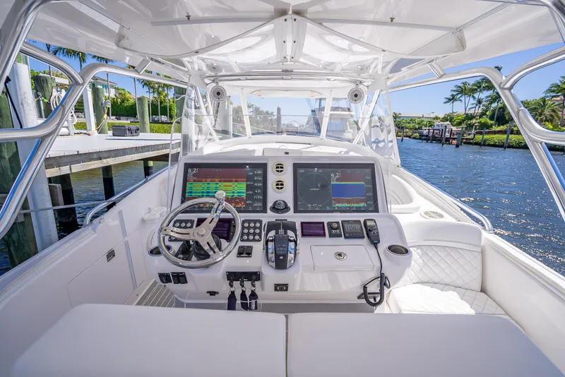 Slide: The Image of 2020 Intrepid 407 Cuddy boat cockpit with advanced navigation system and waterfront view. - 15