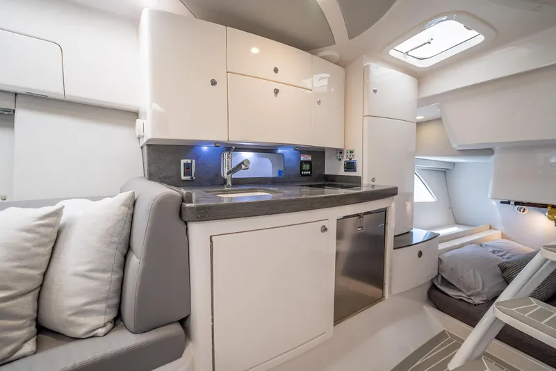 Slide: The Image of 2020 Intrepid 407 Cuddy interior with modern kitchen and cozy seating area. - 20
