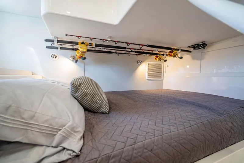 Slide: The Image of Intrepid 407 Cuddy 2020 interior cabin with bed and fishing rod storage. - 21