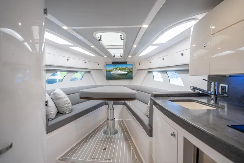 Slide: The Image of 2020 Intrepid 407 Cuddy interior with modern seating, table, and kitchenette. - 22