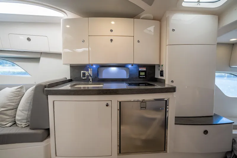 Slide: The Image of 2020 Intrepid 407 Cuddy interior kitchen with modern cabinetry and compact design. - 25