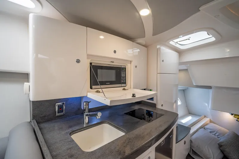 Slide: The Image of Interior of 2020 Intrepid 407 Cuddy, featuring a modern kitchenette and cozy sleeping area. - 26