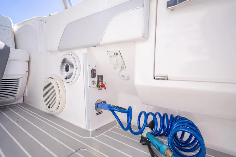Slide: The Image of 2020 Intrepid 407 Cuddy boat interior with speaker and coiled blue hose. - 28