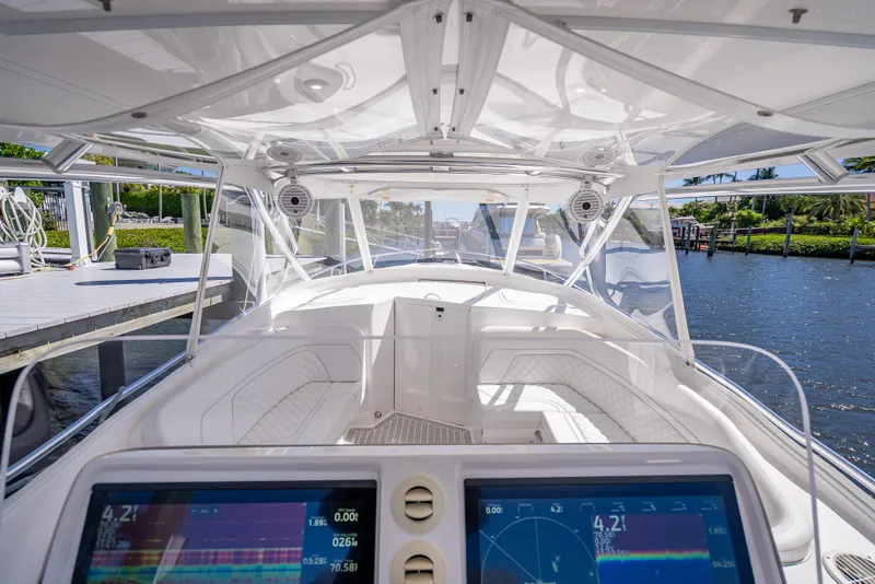 Slide: The Image of 2020 Intrepid 407 Cuddy boat interior with advanced navigation displays, docked by the water. - 31