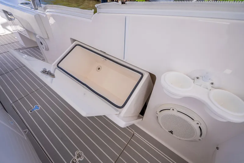 Slide: The Image of 2020 Intrepid 407 Cuddy boat interior with storage compartment and speaker. - 32