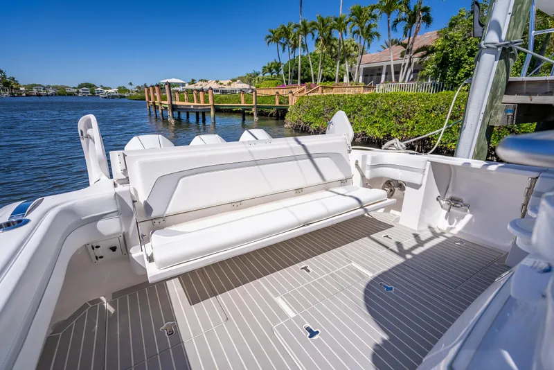 Slide: The Image of 2020 Intrepid 407 Cuddy boat with spacious deck and seating, docked by a scenic waterfront. - 33