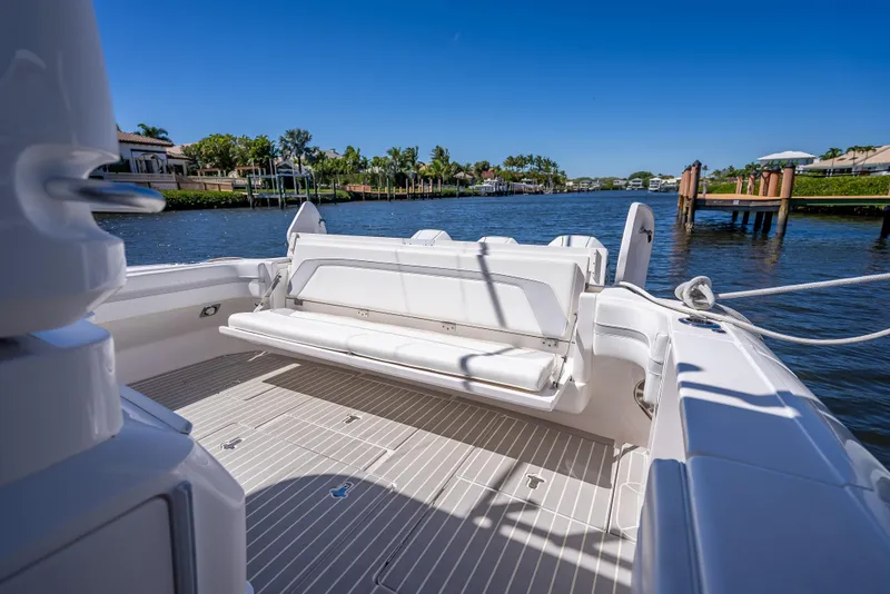 Slide: The Image of Intrepid 407 Cuddy 2020 boat with spacious deck and seating, docked by a scenic waterfront. - 38