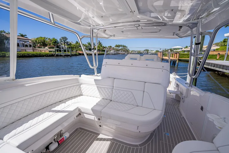 Slide: The Image of 2020 Intrepid 407 Cuddy boat interior with white seating, dockside view. - 48