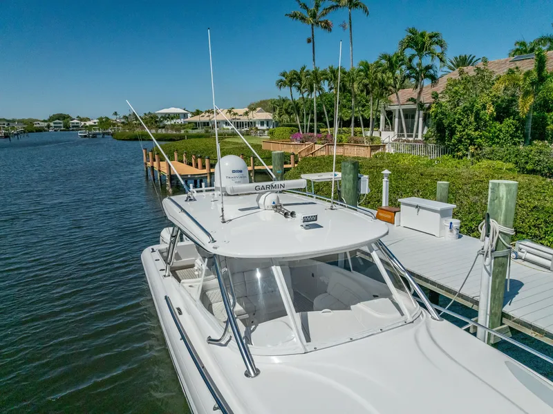 Slide: The Image of 2020 Intrepid 407 Cuddy docked by a scenic waterfront with lush greenery. - 7