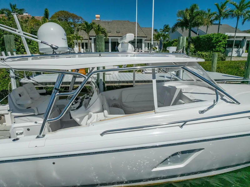 Slide: The Image of 2020 Intrepid 407 Cuddy boat docked, featuring sleek design and spacious seating. - 8