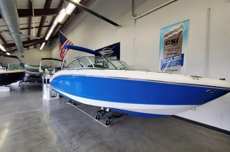 Slide: The Image of 2019 Chaparral 21 H2O OB Sport boat in showroom, blue and white exterior. - 3