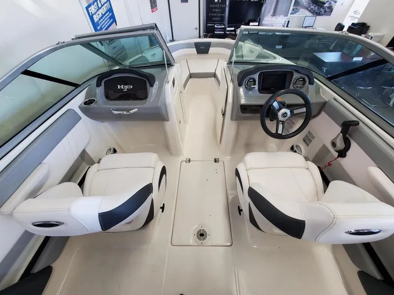 Slide: The Image of 2019 Chaparral 21 H2O OB Sport boat interior with dual seating and steering console. - 8
