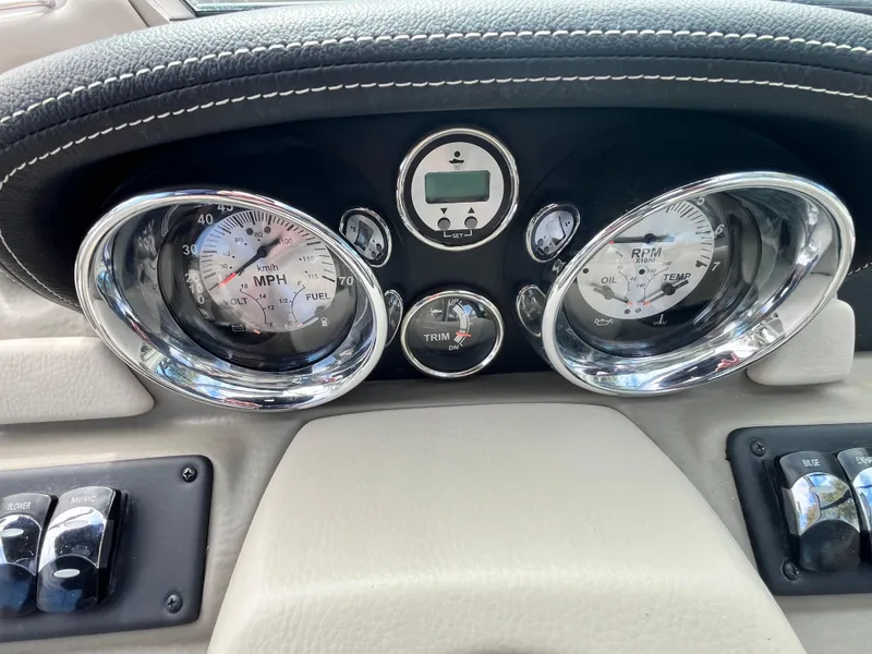 Slide: The Image of Dashboard of a 2021 Crownline 220SS boat with chrome-trimmed gauges and controls. - 13