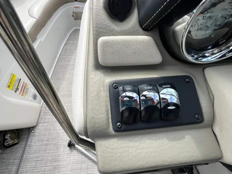 Slide: The Image of Dashboard controls of a 2021 Crownline 220SS boat, featuring switches and speedometer. - 14