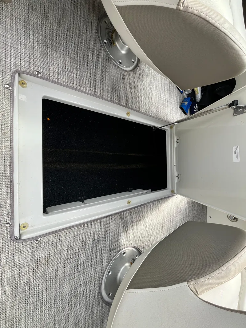 Slide: The Image of 2021 Crownline 220SS boat interior storage compartment with gray carpet and seating. - 21