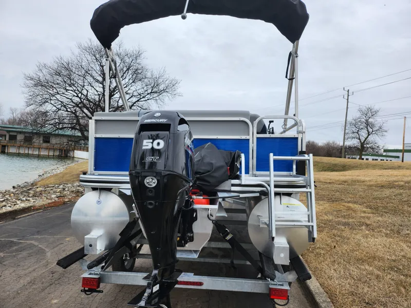 Slide: The Image of 2022 Lowe Ultra 160 Cruise pontoon boat with Mercury 50 HP engine, docked on a trailer. - 2