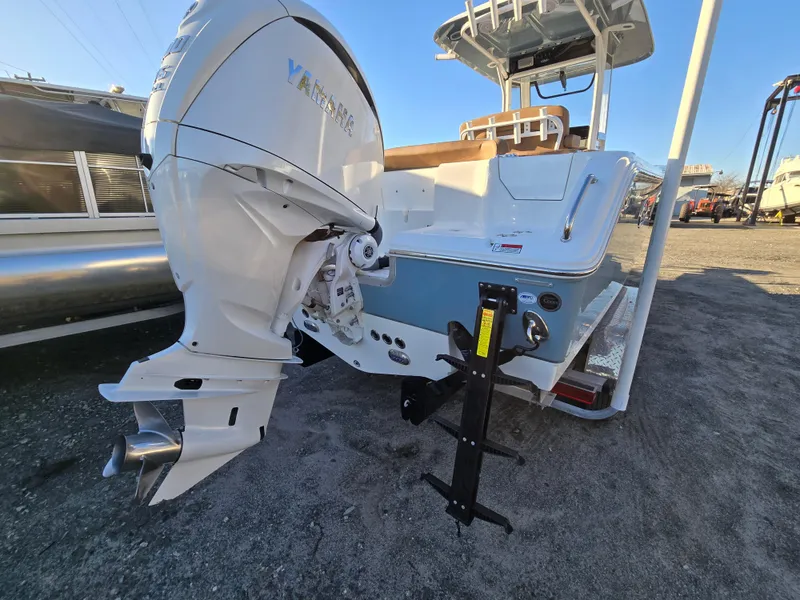 Slide: The Image of 2022 Sea Hunt Ultra 255 SE boat with powerful outboard motor, docked on gravel. - 10