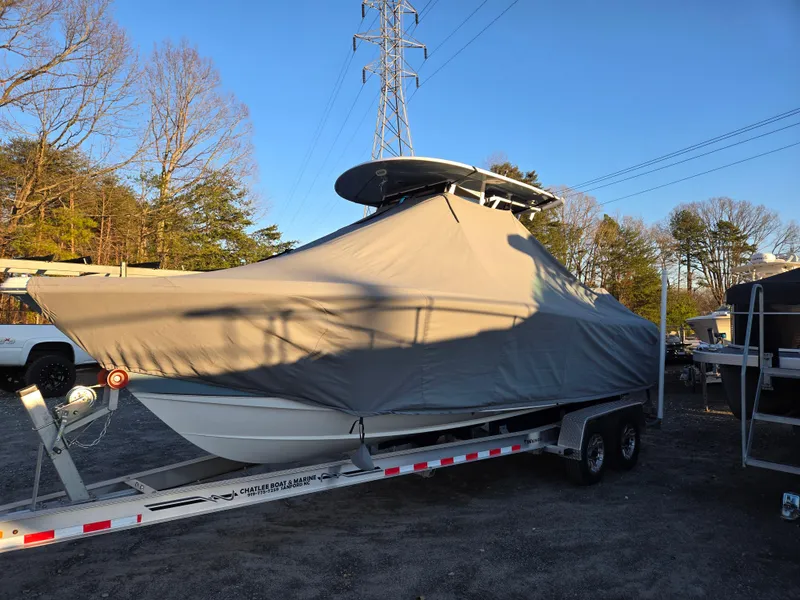 Slide: The Image of 2022 Sea Hunt Ultra 255 SE boat covered on trailer, parked outdoors. - 13