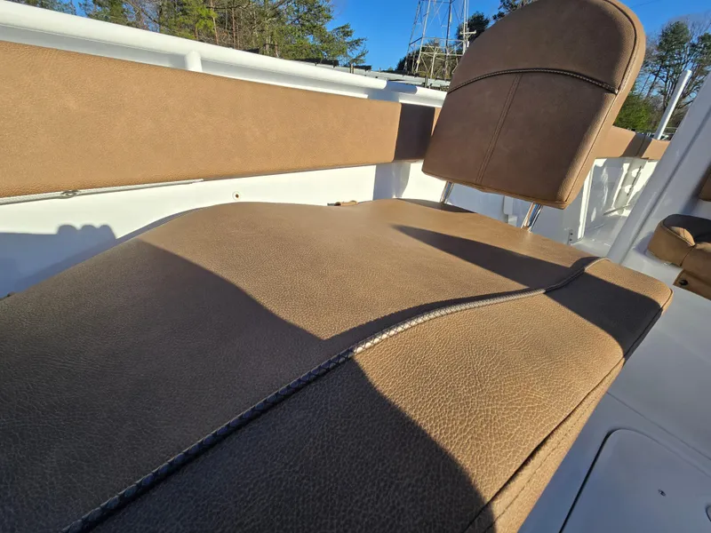 Slide: The Image of 2022 Sea Hunt Ultra 255 SE boat interior with brown cushioned seating. - 16
