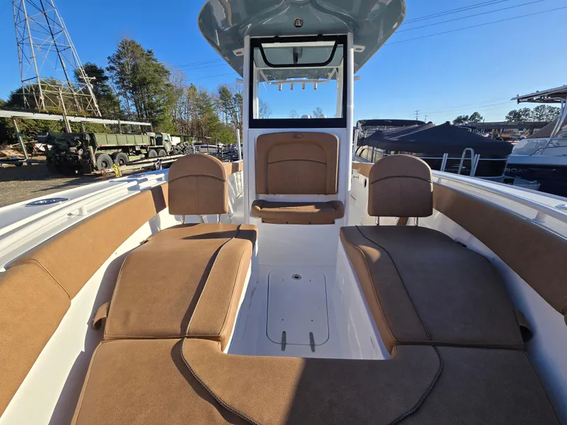 Slide: The Image of 2022 Sea Hunt Ultra 255 SE boat interior with cushioned seating and console. - 18