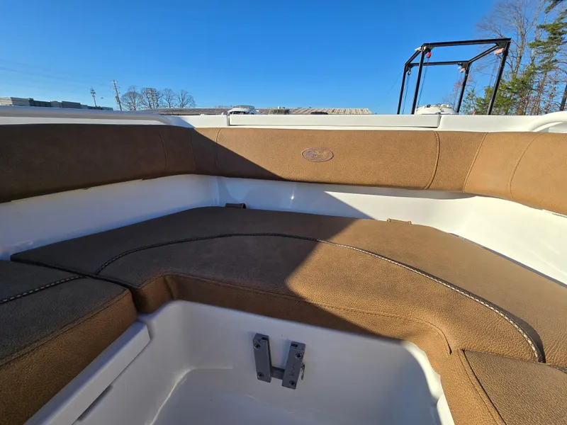 Slide: The Image of 2022 Sea Hunt Ultra 255 SE boat interior with brown cushioned seating. - 19