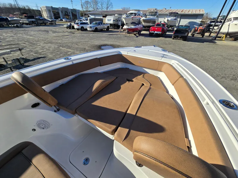 Slide: The Image of 2022 Sea Hunt Ultra 255 SE boat with spacious tan seating in a marina setting. - 20