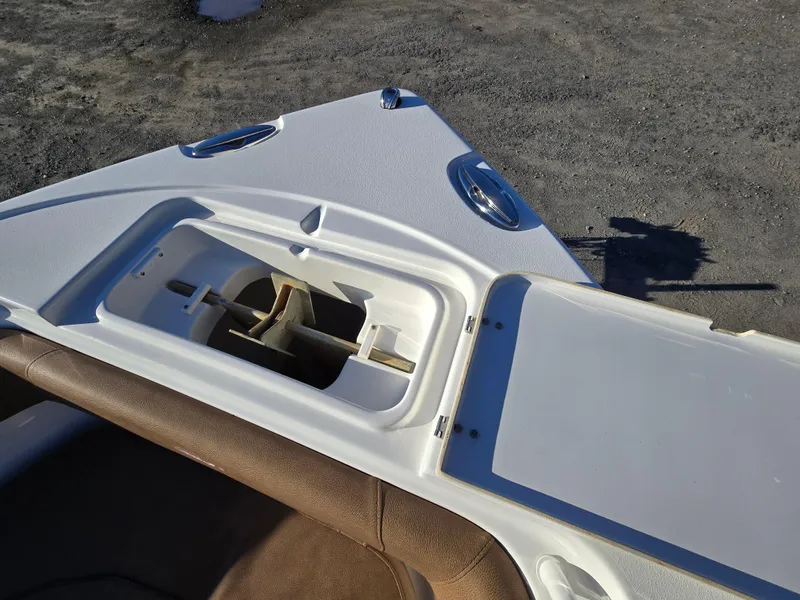 Slide: The Image of 2022 Sea Hunt Ultra 255 SE boat anchor storage compartment, open lid, on deck. - 24