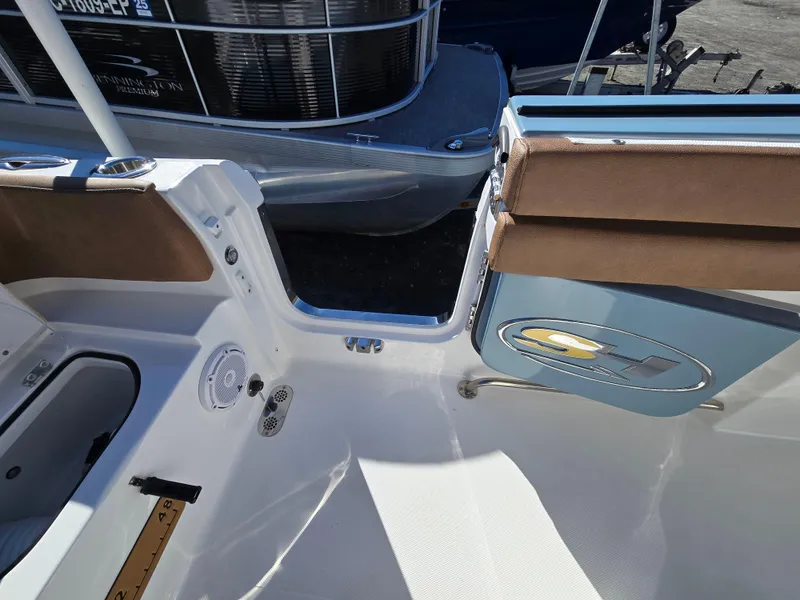 Slide: The Image of 2022 Sea Hunt Ultra 255 SE boat interior with open side door and seating. - 25