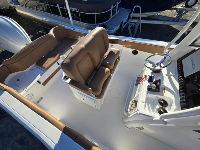 Slide: The Image of 2022 Sea Hunt Ultra 255 SE boat interior with brown seating and modern controls. - 32