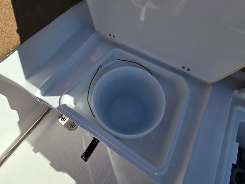 Slide: The Image of 2022 Sea Hunt Ultra 255 SE boat storage compartment with bucket. - 35