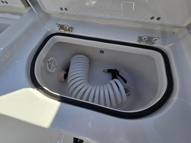 Slide: The Image of Storage compartment with hose in 2022 Sea Hunt Ultra 255 SE boat. - 37