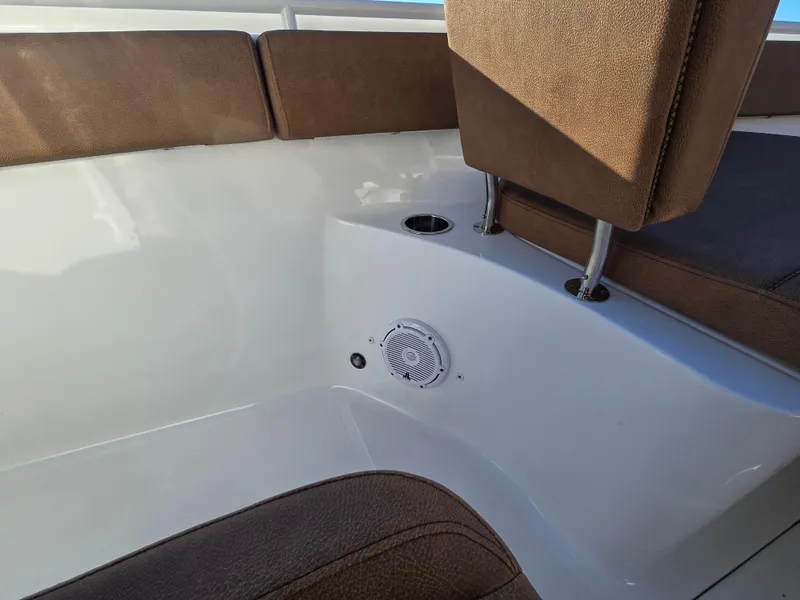 Slide: The Image of 2022 Sea Hunt Ultra 255 SE boat interior with brown seating and speaker. - 43