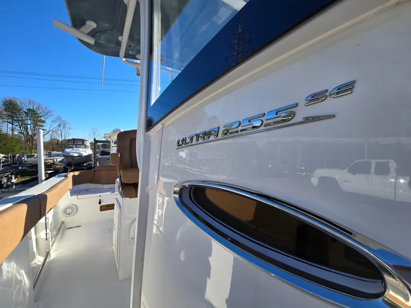 Slide: The Image of 2022 Sea Hunt Ultra 255 SE boat, sleek design, white exterior, sunny day. - 46