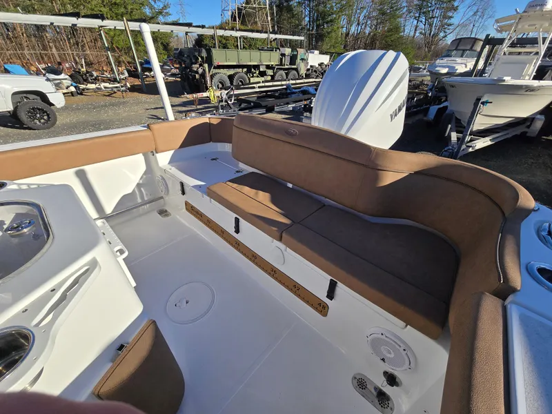 Slide: The Image of 2022 Sea Hunt Ultra 255 SE boat interior with brown seating and white deck. - 49