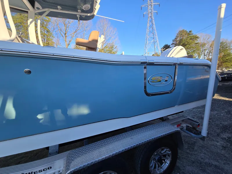Slide: The Image of 2022 Sea Hunt Ultra 255 SE boat on trailer, side view, blue hull. - 8