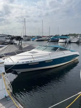 The Image of 1996 Sea Ray 240 Overnighter boat docked in a marina under cloudy skies. - 1