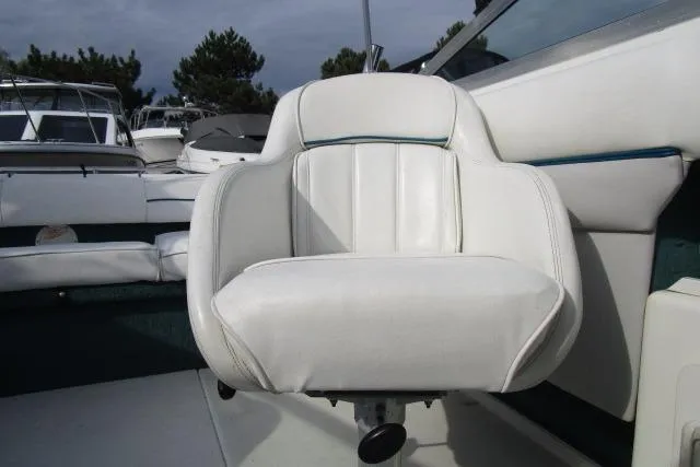 Slide: The Image of White captain's chair on 1996 Sea Ray 240 Overnighter boat, docked with other vessels. - 12