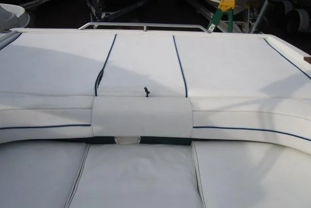 Slide: The Image of 1996 Sea Ray 240 Overnighter boat with white cushioned seating and blue trim. - 15