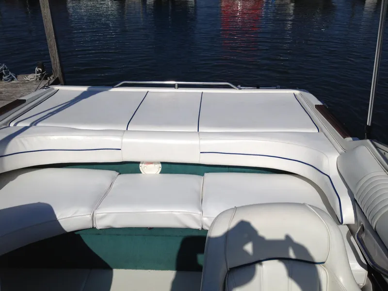 Slide: The Image of 1996 Sea Ray 240 Overnighter boat interior with white seating and water view. - 7