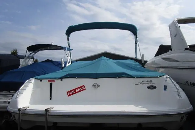Slide: The Image of 1996 Sea Ray 240 Overnighter boat with blue cover, for sale sign visible. - 9