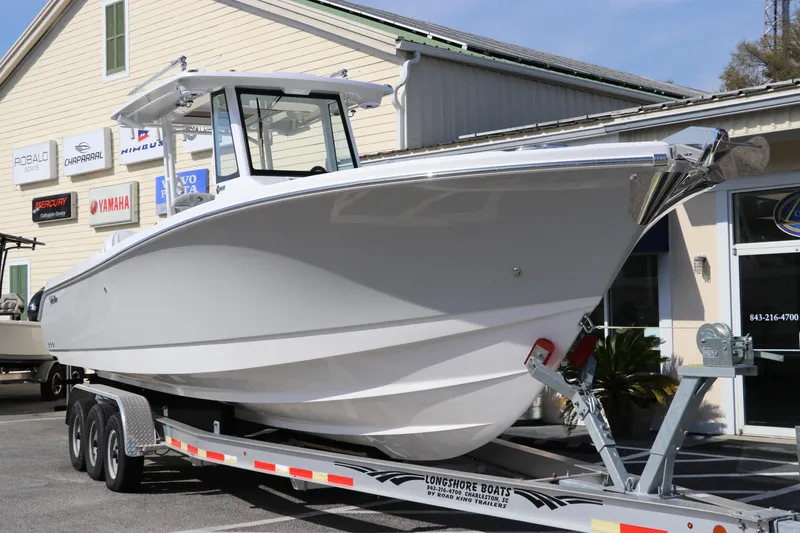 Slide: The Image of 2025 Edgewater 325CC boat on trailer outside dealership. - 1