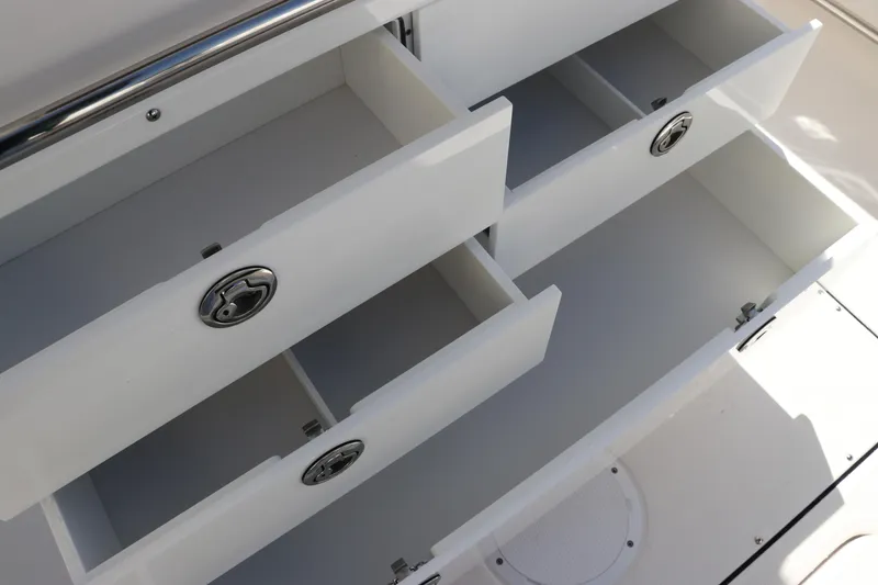 Slide: The Image of 2025 Edgewater 325CC boat storage drawers with sleek chrome handles. - 16