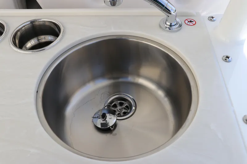 Slide: The Image of 2025 Edgewater 325CC boat console with cup holders and storage compartment. - 19