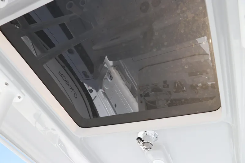 Slide: The Image of 2025 Edgewater 325CC boat with T-top and rod holders, viewed from below. - 24