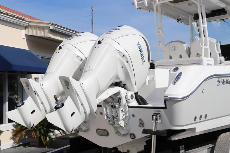 Slide: The Image of 2025 Edgewater 325CC boat with T-top, parked near a building. - 3
