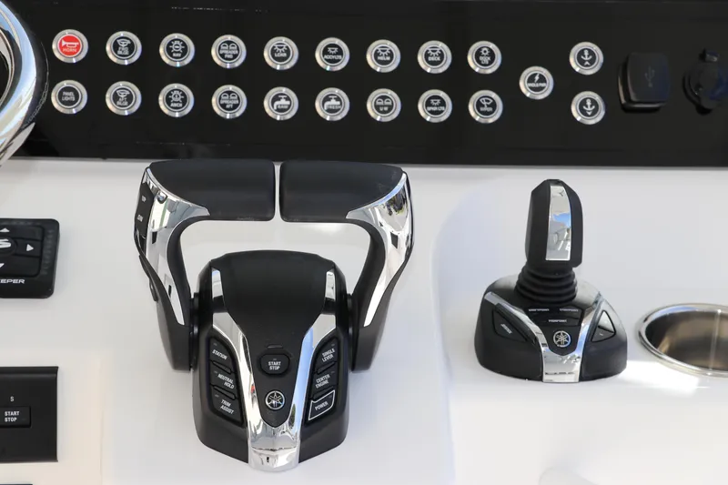 Slide: The Image of 2025 Edgewater 325CC boat dashboard with Garmin displays and control buttons. - 38